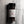 A 3 oz clear plastic spice jar of Casa Flake Black Peppercorns with a black lid and white label, set against a gray marble background.