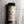 A clear plastic spice jar of Casa Flake California Onion Powder with a black lid and white label, set against a gray marble background.