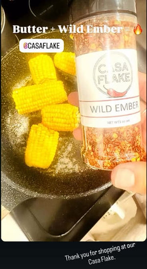 Casa Flake Wild Ember seasoning bottle held over corn on a pan with text overlay.