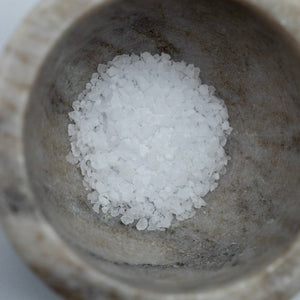 Close-up of a stone mortar with salt inside