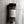 A clear plastic shaker bottle of Casa Flake Medium Grind Black Pepper seasoning, featuring a white label with a red chili pepper graphic and a black lid, set against a gray marble background.