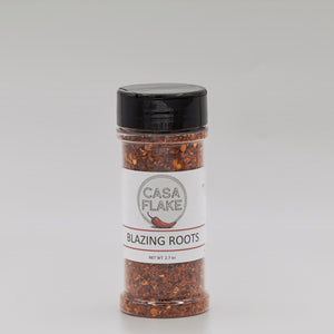 Spice jar labeled 'Casa Flake Blazing Roots' on a gray background