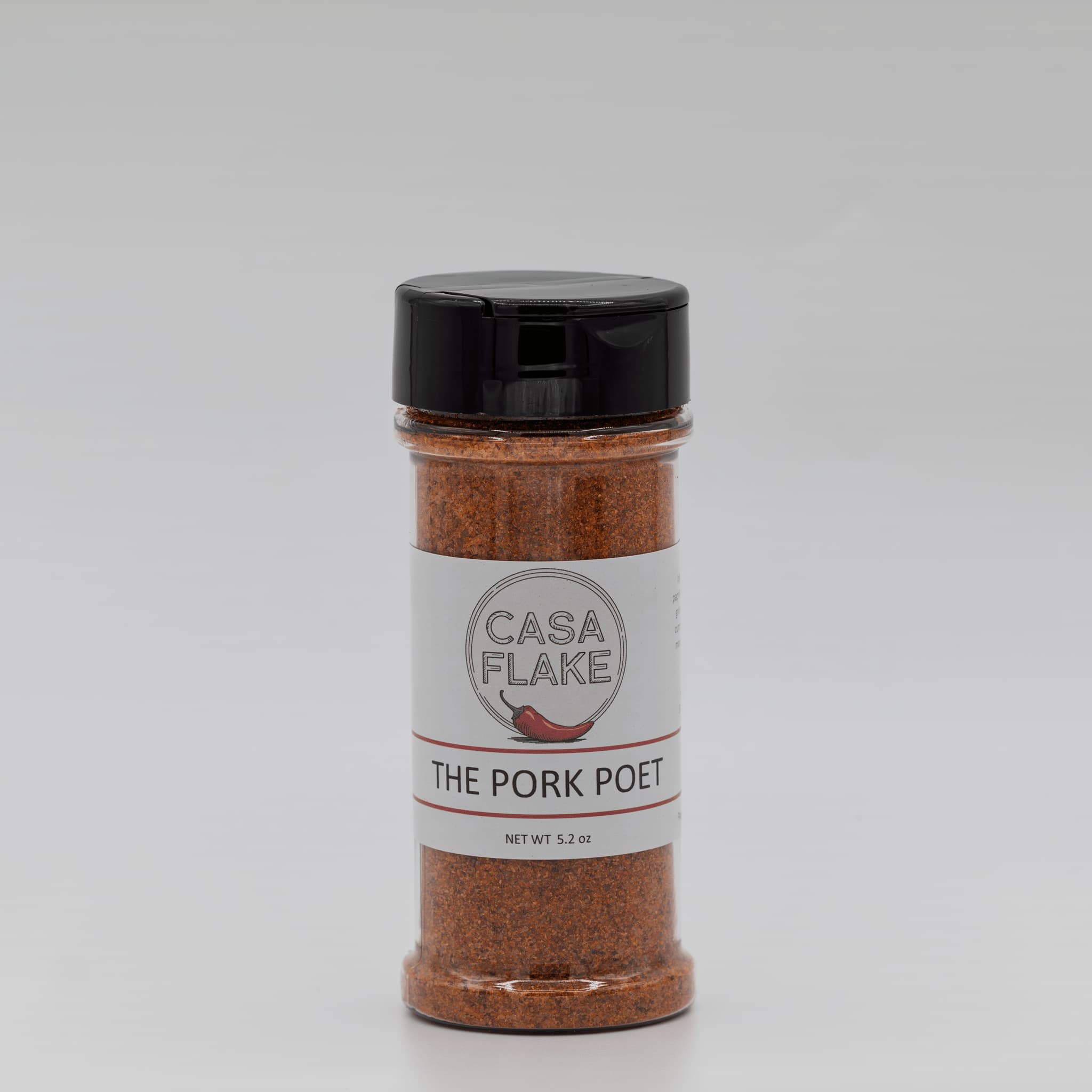 Spice jar labeled 'The Pork Poet' by Casa Flake on a gray background